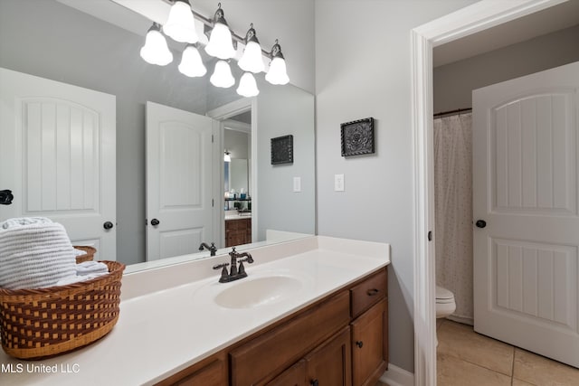 full bathroom featuring a notable chandelier, vanity, toilet, and tile patterned floors