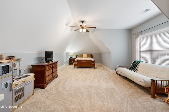 bedroom with lofted ceiling, light colored carpet, a sink, visible vents, and baseboards