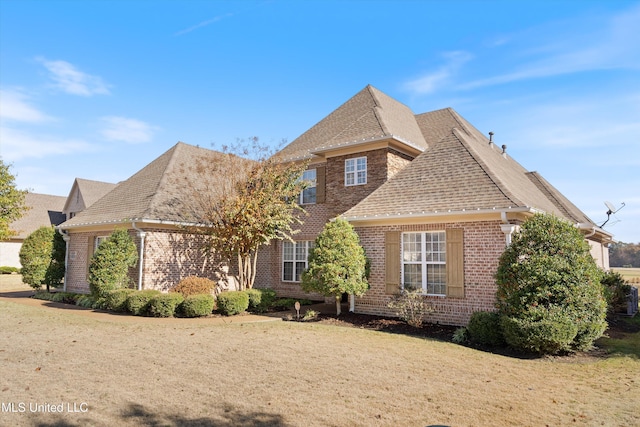 view of front of home with a shingled roof and brick siding