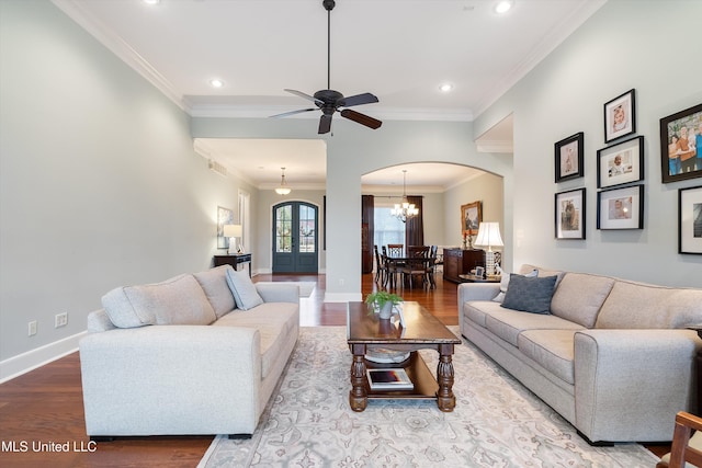 living area featuring arched walkways, crown molding, recessed lighting, wood finished floors, and baseboards