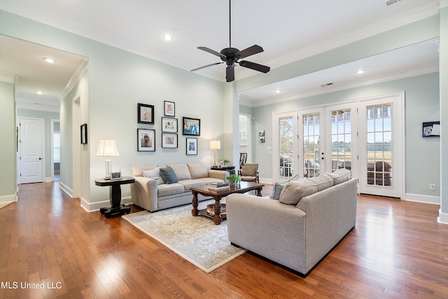 living room featuring hardwood / wood-style flooring, ornamental molding, and french doors