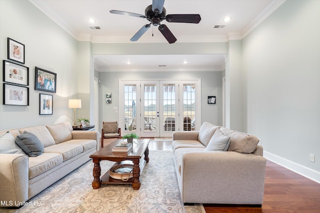 living area with baseboards, visible vents, ornamental molding, wood finished floors, and french doors