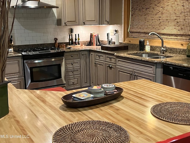 kitchen with tasteful backsplash, sink, gray cabinets, wall chimney exhaust hood, and stainless steel appliances