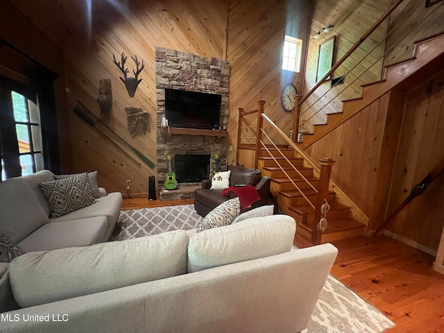 living room featuring hardwood / wood-style floors, a fireplace, and wood walls