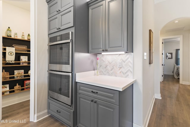 2918 Juliette Dr, Ocean Springs, MS 39564 - kitchen featuring gray cabinets, double oven, dark wood-style flooring, and arched walkways