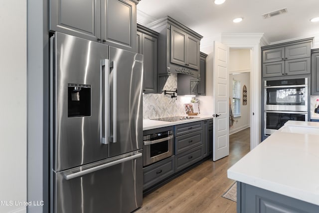 2918 Juliette Dr, Ocean Springs, MS 39564 - kitchen featuring stainless steel appliances, gray cabinetry, decorative backsplash, light countertops, and ornamental molding