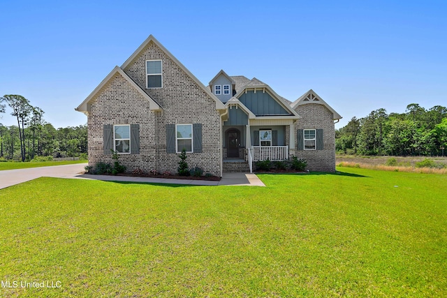2918 Juliette Dr, Ocean Springs, MS 39564 - craftsman-style house featuring a front yard, brick siding, board and batten siding, and covered porch