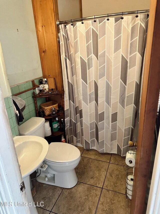 90 Holmes St, Lucedale, MS 39452 - bathroom with toilet, tile patterned flooring, tile walls, wainscoting, and curtained shower