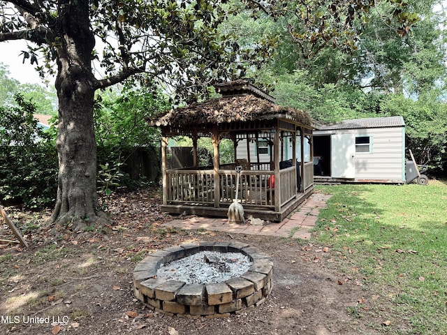 90 Holmes St, Lucedale, MS 39452 - view of grassy yard featuring an outdoor fire pit, a gazebo, a storage shed, and an outdoor structure