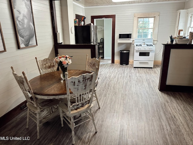 90 Holmes St, Lucedale, MS 39452 - dining room featuring wood finished floors, wooden walls, and baseboards