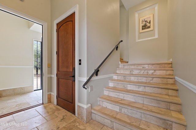 foyer featuring stairs and stone tile floors