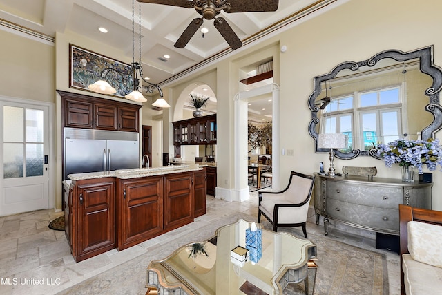 kitchen featuring a towering ceiling, coffered ceiling, a healthy amount of sunlight, and stainless steel built in refrigerator