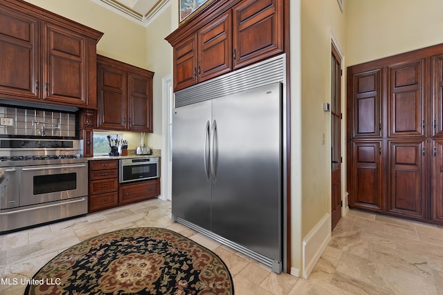 kitchen with light stone counters, baseboards, appliances with stainless steel finishes, tasteful backsplash, and crown molding