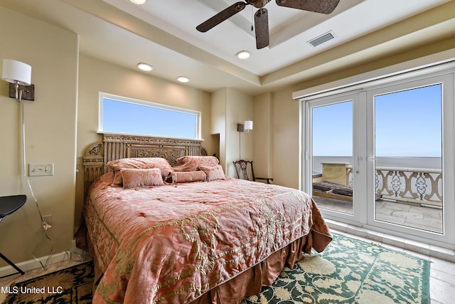 bedroom with a tray ceiling, french doors, visible vents, a ceiling fan, and access to outside