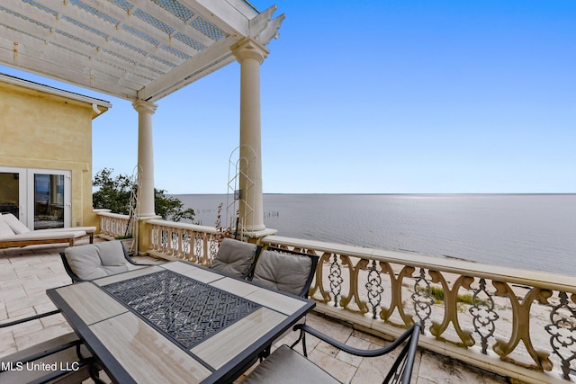 wooden terrace featuring a water view and a pergola