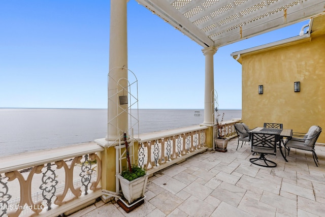 view of patio / terrace with outdoor dining space, a water view, and a pergola