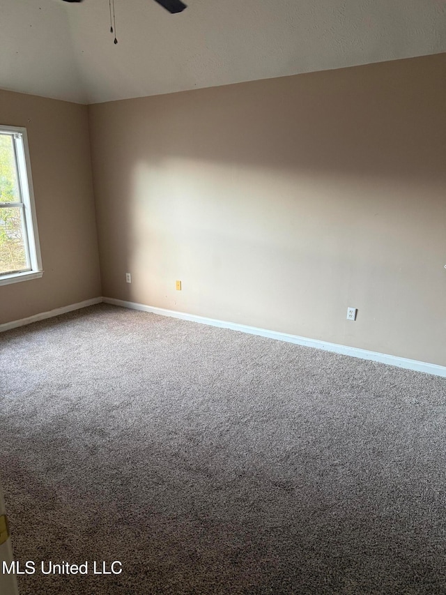 carpeted empty room featuring vaulted ceiling and ceiling fan