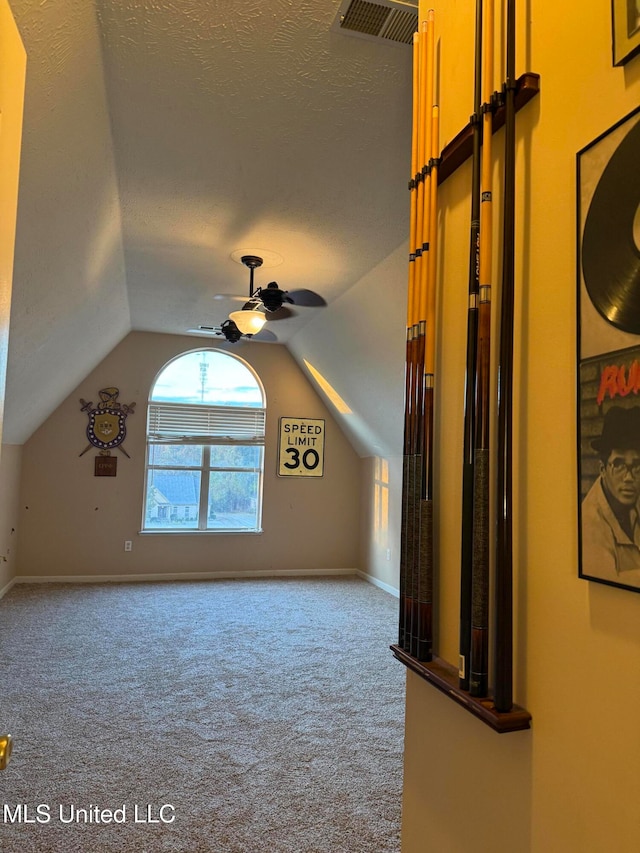 bonus room with lofted ceiling, ceiling fan, carpet floors, and a textured ceiling