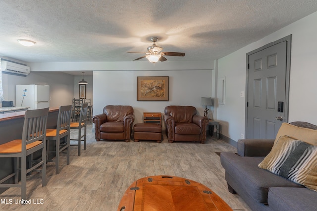 95 Nesting Site, Vicksburg, MS 39183 - living area featuring a textured ceiling, light wood-style flooring, a wall mounted air conditioner, and ceiling fan