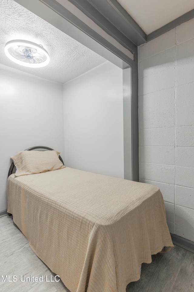 95 Nesting Site, Vicksburg, MS 39183 - bedroom featuring light wood finished floors, a textured ceiling, and concrete block wall