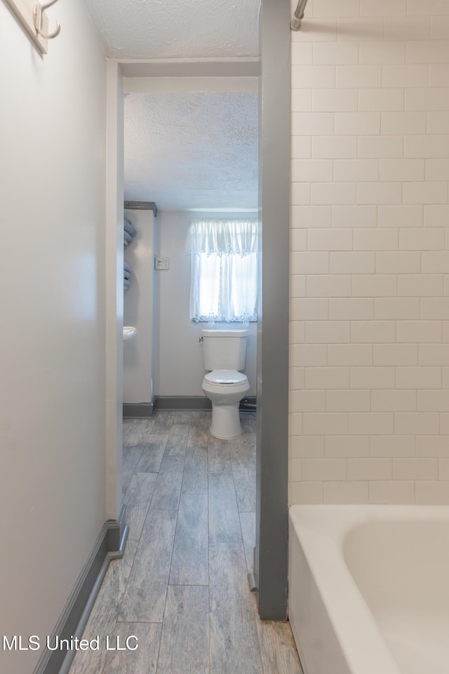 95 Nesting Site, Vicksburg, MS 39183 - full bathroom featuring a textured ceiling, toilet, baseboards, and wood finished floors