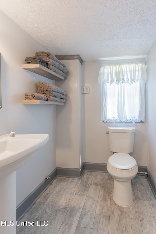 95 Nesting Site, Vicksburg, MS 39183 - half bathroom with toilet, wood finished floors, baseboards, and a textured ceiling