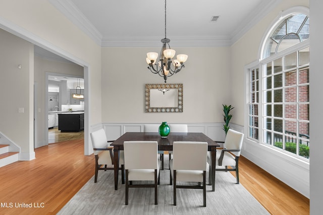 dining area featuring light hardwood / wood-style floors, ornamental molding, and a wealth of natural light