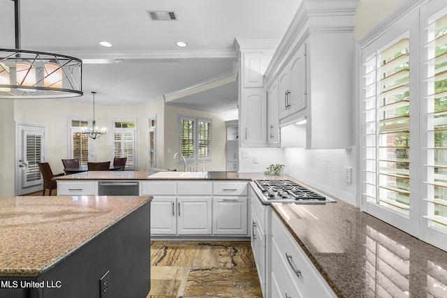 kitchen featuring appliances with stainless steel finishes, white cabinetry, sink, and plenty of natural light