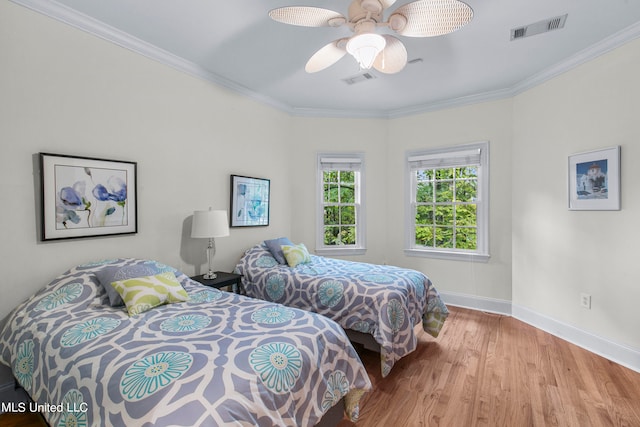 bedroom featuring light hardwood / wood-style flooring, crown molding, and ceiling fan