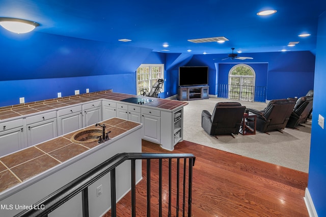 interior space with sink, vaulted ceiling, light wood-type flooring, and ceiling fan