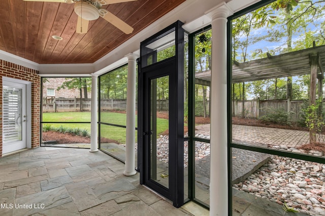 unfurnished sunroom with ceiling fan and wooden ceiling