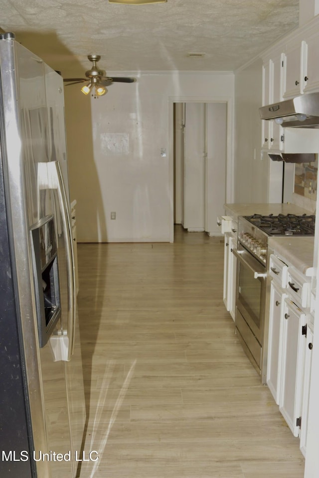 219 Lake Cove Dr, Jackson, MS 39212 - kitchen featuring under cabinet range hood, stainless steel range, white cabinets, light wood-type flooring, and light countertops