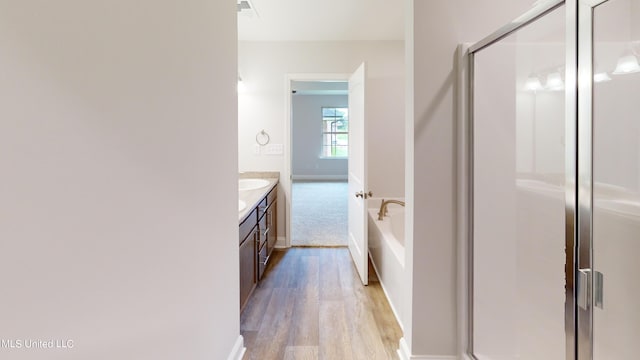 bathroom featuring vanity, separate shower and tub, and hardwood / wood-style floors