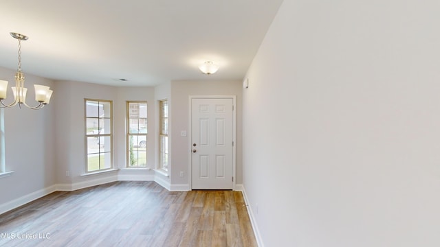 foyer entrance featuring an inviting chandelier and light hardwood / wood-style floors