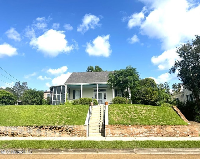 view of front of property with covered porch and a front lawn