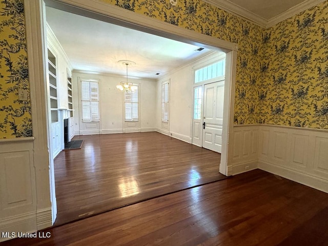 interior space with a notable chandelier, crown molding, built in features, and dark wood-type flooring