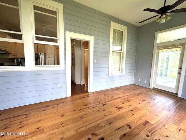 unfurnished sunroom featuring ceiling fan and sink