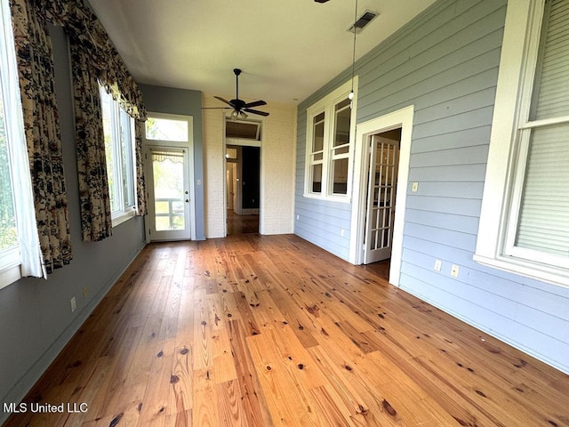 unfurnished sunroom featuring ceiling fan