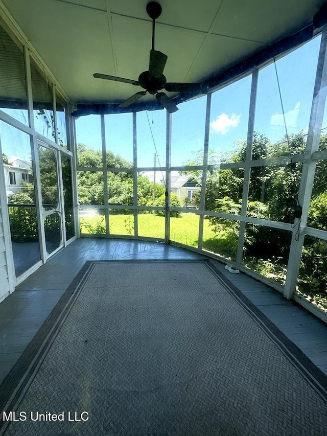 unfurnished sunroom with ceiling fan