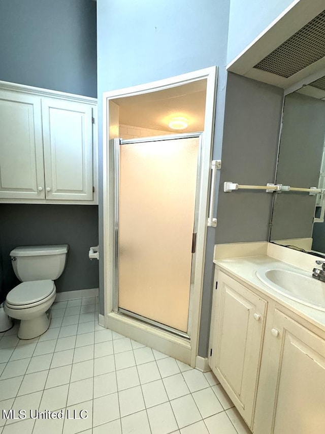 bathroom with tile patterned floors, vanity, a shower with shower door, and toilet