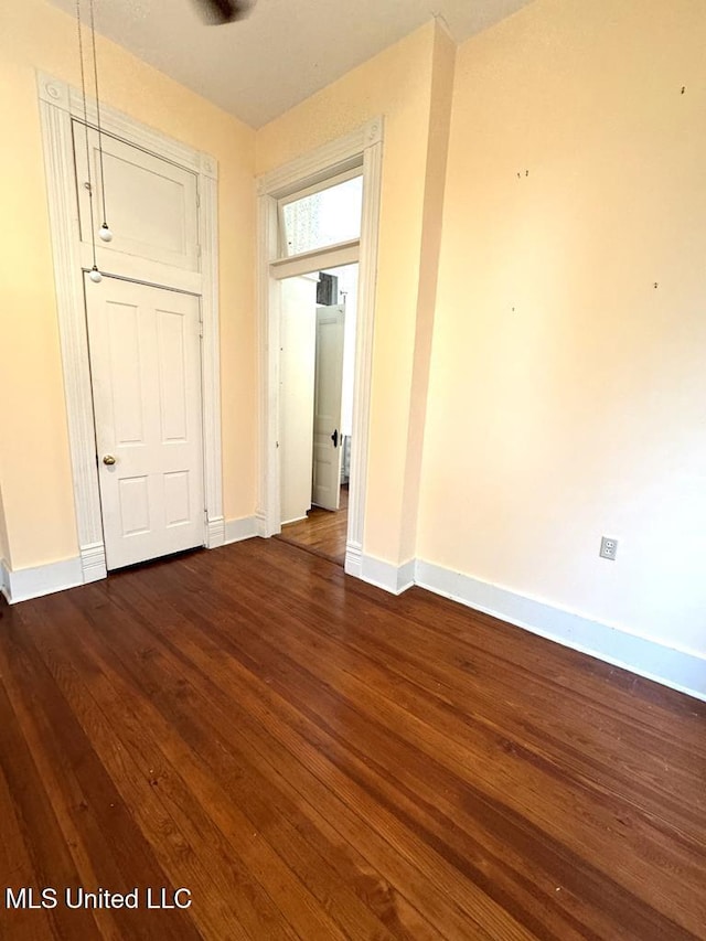 unfurnished room with dark wood-type flooring