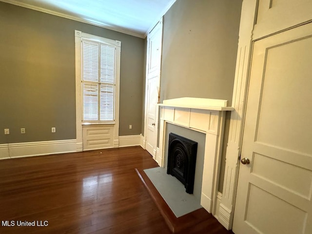 unfurnished living room with dark hardwood / wood-style flooring and ornamental molding