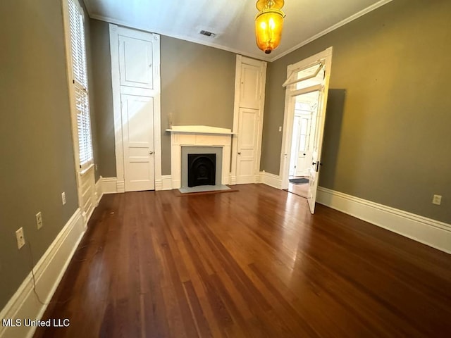 unfurnished living room featuring crown molding and dark wood-type flooring