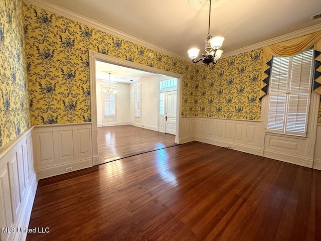 interior space with a healthy amount of sunlight, hardwood / wood-style floors, ornamental molding, and an inviting chandelier