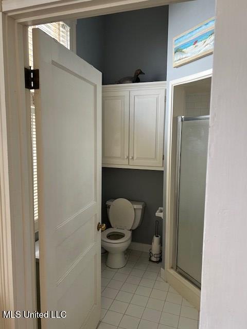 bathroom with toilet, tile patterned floors, and walk in shower