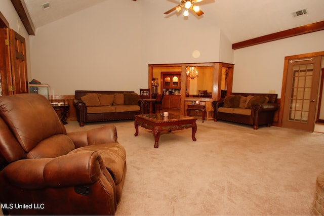 carpeted living room with high vaulted ceiling and ceiling fan with notable chandelier