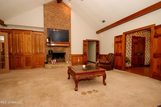 carpeted living room featuring beamed ceiling, a wood stove, wood walls, and high vaulted ceiling