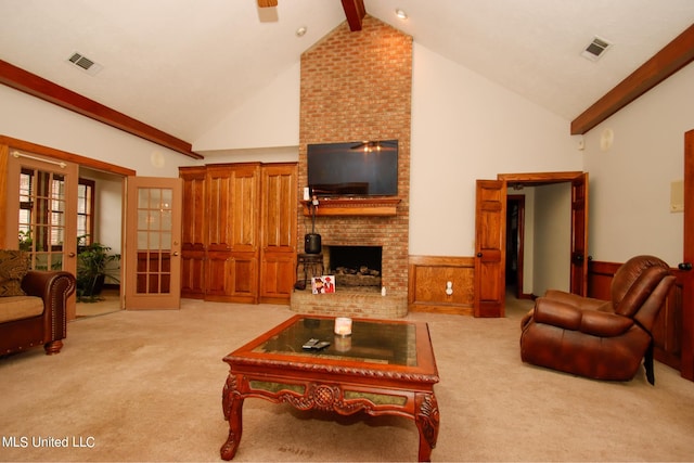 carpeted living room with french doors, beamed ceiling, high vaulted ceiling, and a fireplace