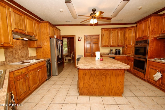 kitchen featuring crown molding, a center island, light tile patterned floors, appliances with stainless steel finishes, and ceiling fan