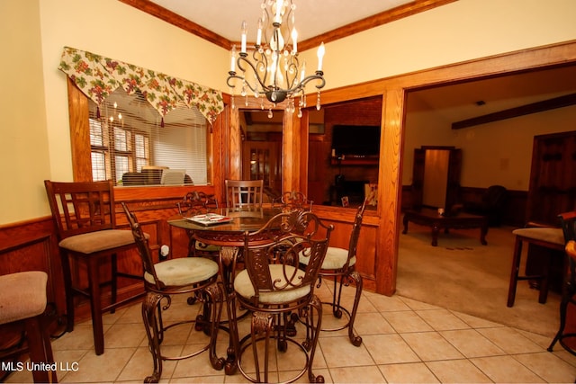 carpeted dining space featuring ornamental molding, a chandelier, wooden walls, and indoor bar